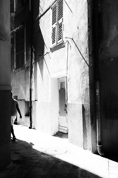 A man walking down a street in Old Nice, France