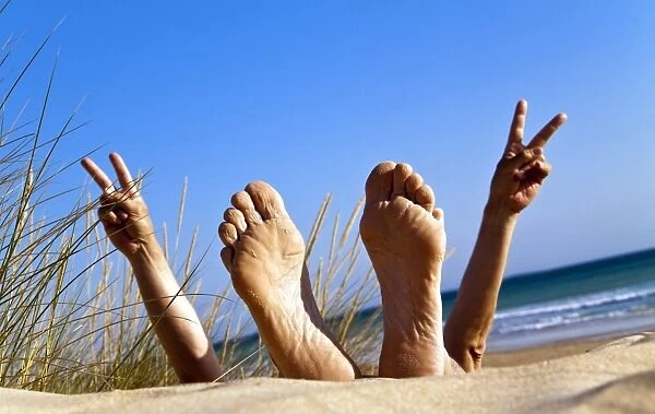 Mens feet in a sand dune by the sea