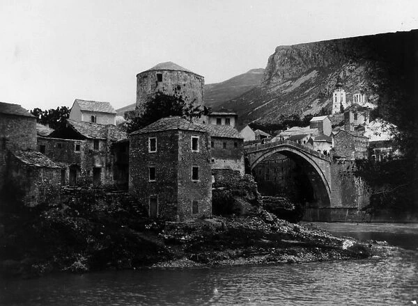 Mostar. circa 1910: The stone arch bridge over the River Neretva in the