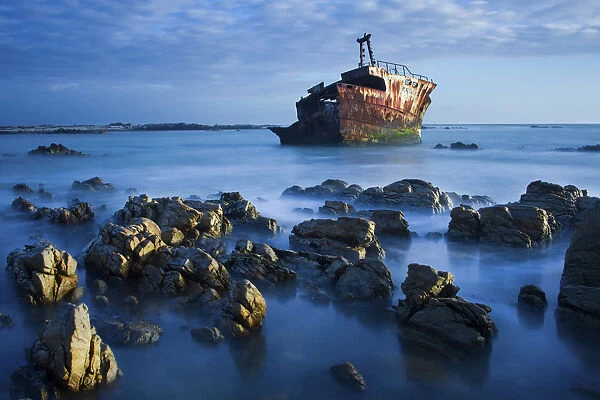 Old shipwreck long exposure on the rocks at sunset - Cape LAgulhas South Africa
