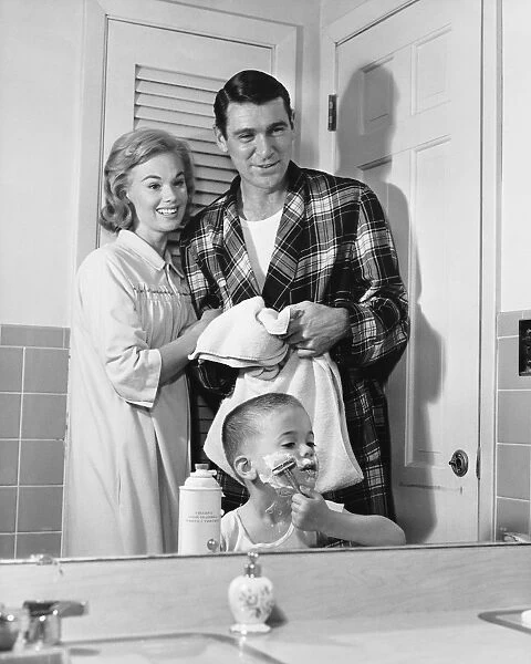 Parents watching as son pretends to shave