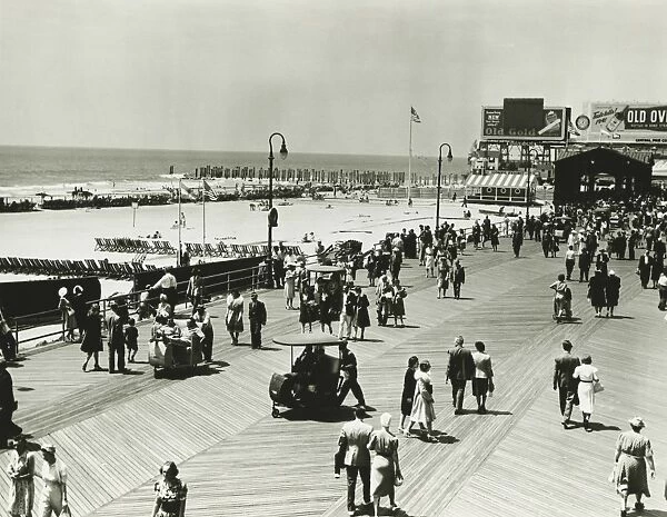 People walking on promenade by seashore, (B&W), (Elevated view)