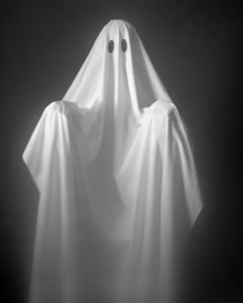 Person Wearing A Ghost Costume, Made Out Of A White Sheet With Two Holes In It