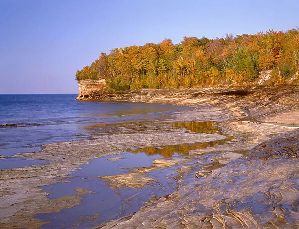 Sandstone shoreline by Lake Superior and autumn forest at Mosquito Beach, Pictured Rocks National Lakeshore, Michigan, USA