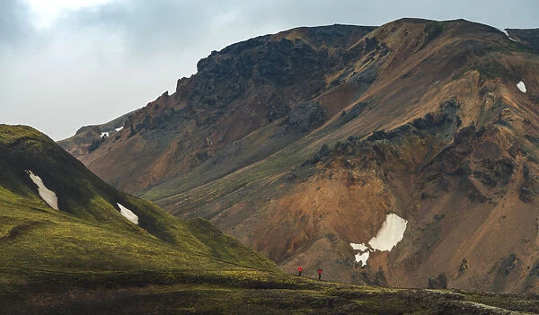 travellers walking at the volcanic landscape of landmannalaugar