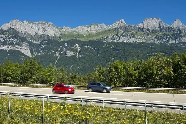 Vehicles on the A3 motorway in front of the Churfirsten range near Lake Walen, Canton of St. Gallen, Switzerland