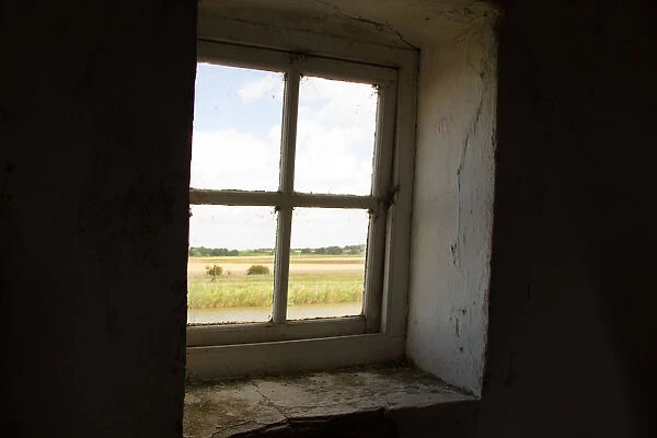 A window looks out from the Tracey Arms Drainage Mill over the River Bure and the