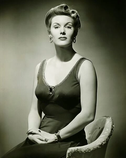 Woman in evening dress posing in studio, (B&W), portrait