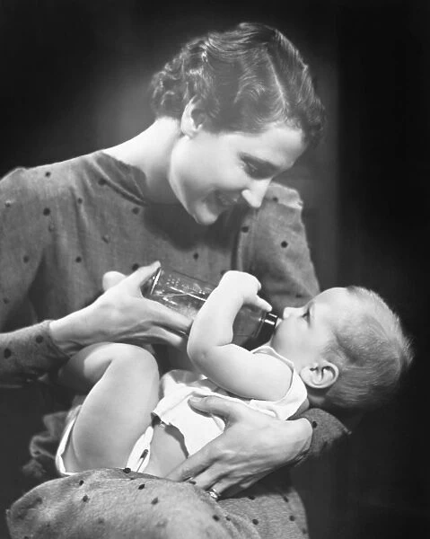 Woman feeding baby (6-9 months) in studio (B&W)