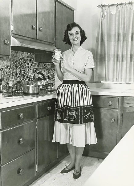 Woman posing in kitchen, (B&W), portrait