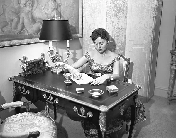 Woman writing at desk with quill pen, (B&W), elevated view