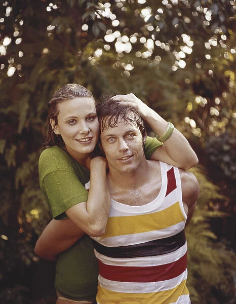 Young woman and man in wet clothes embracing, close-up, portrait, smiling