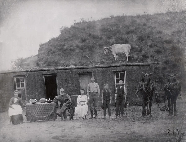 American pioneer family in front of their home (b  /  w photo)
