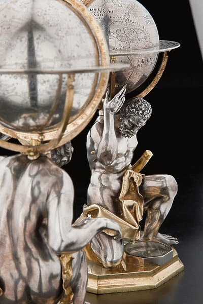 Two exceptional terrestrial and celestial globes, supported by Hercules and Atlas