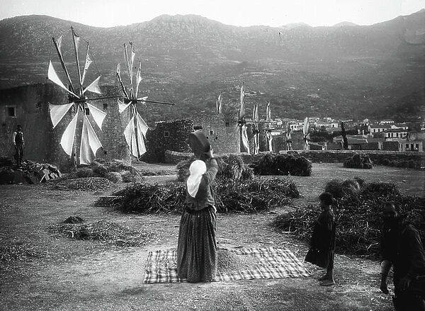 Greece, Niepili, CR, Niepili: Oriental Life Scene. Manual waving of the wheat in front of six Cretan windmills in a mountain landscape, 1908