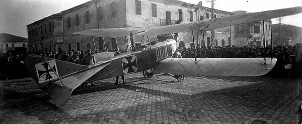 Greece, Thessaloniki: German biplane landing in catastoph in the middle of a road, guard by French soldiers and surrounded by a band of curious people, 1916