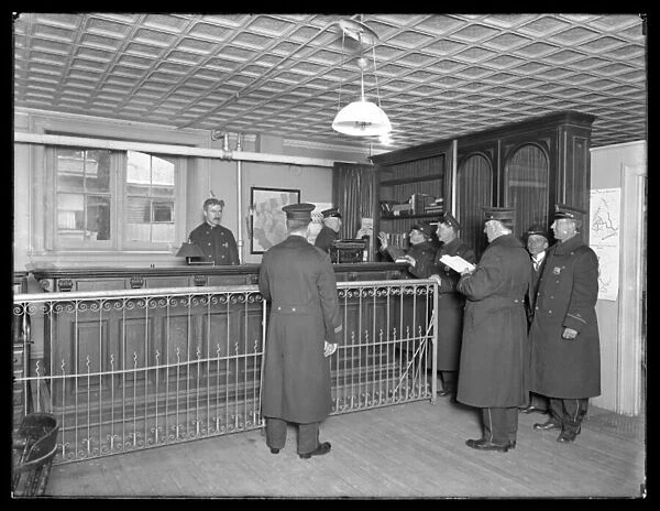 Interior of unidentified police station, showing officers and front desk, c