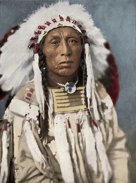 Portrait of Indian Chief Crow, wearing traditional suede clothing and eagle feather warcap, circa 1900