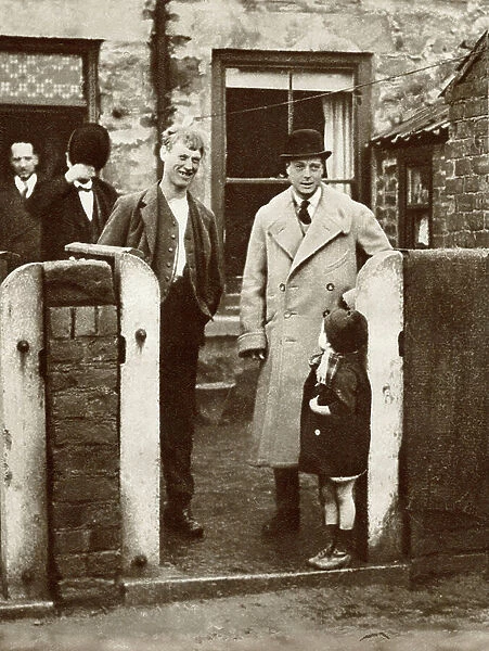The Prince of Wales, later King Edward VIII visiting a miner's house and family in Durham in 1929. From The Story of 25 Eventful Years in Pictures published 1935