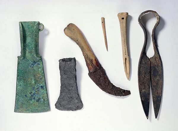 Selection of tools: L-R: early Iron Age bronze axe with bent-over wings; later iron axe