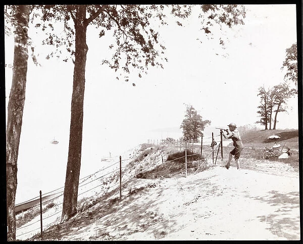 View of a boy with a spyglass looking toward the Hudson River from Riverside Park