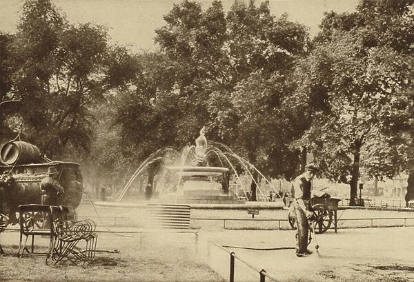 Workmen spraying tar on the gravel in front of a fountain beside Park Lane (b  /  w photo)