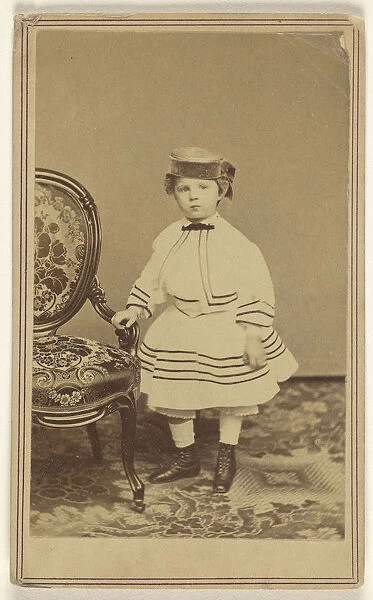 little girl wearing pill-box hat standing holding