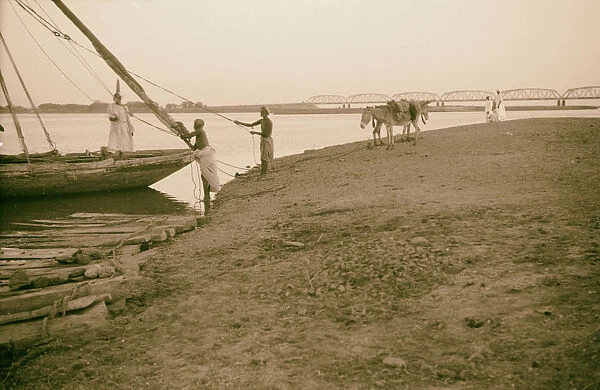 Men boat shores Nile River Omdurman Bridge background