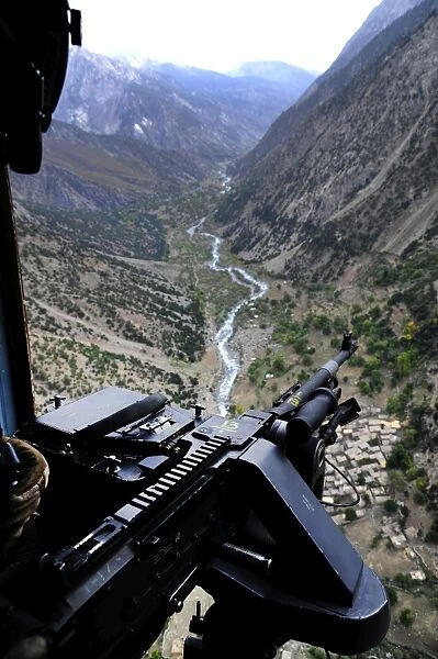 An aerial gunner surveys the surrounding area during a combat mission in Afghanistan