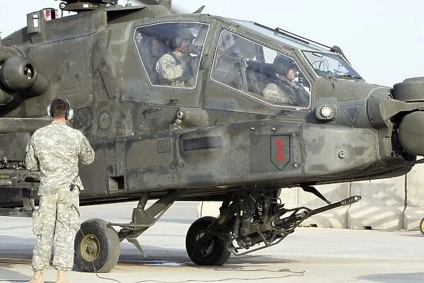 An AH-64 Apache prepares to leave its pad for a mission