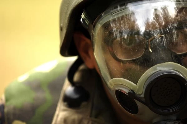 Airman dons a gas mask during a simulated gas attack