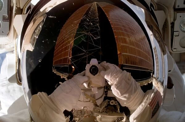 Astronaut uses a digital still camera to expose a photo of her helmet visor during