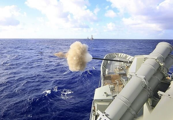 The Australian navy frigate HMAS Warramunga fires its 5-inch gun during a surface