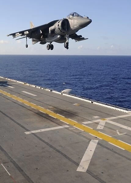 An AV-8B Harrier jet prepares to land on the flight deck of USS Essex
