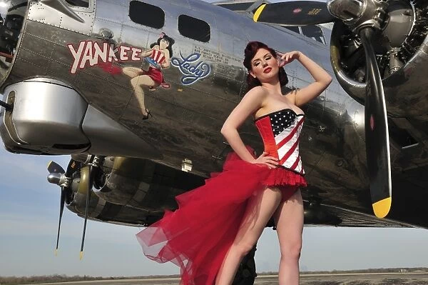Beautiful 1940s style pin-up girl standing under a B-17