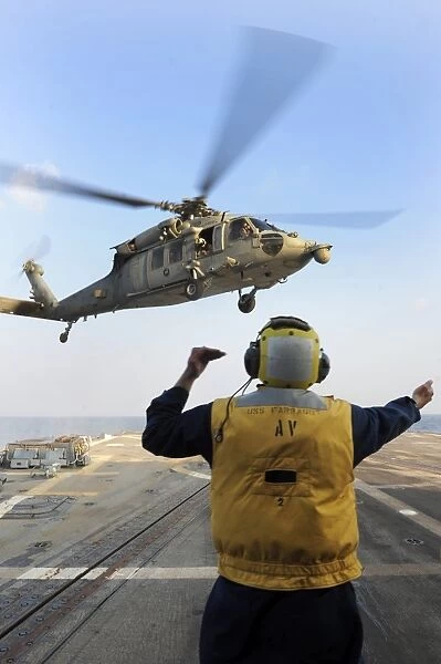 Boatswainas Mate directs an MH-60S Sea Hawk aboard USS Farragut