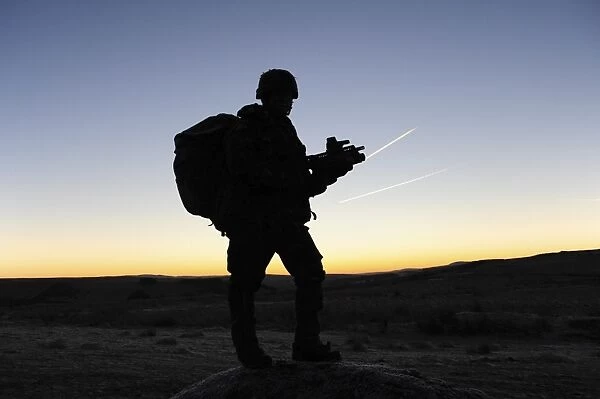 A British soldier on patrol as the Sun rises