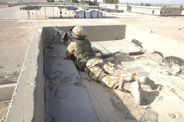 A British soldier provides security from a rooftop in Basra, Iraq