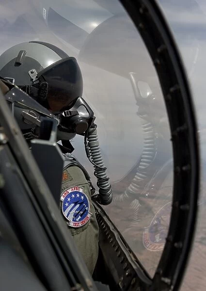 An F-16 pilot checks the position of his wingman during a test mission