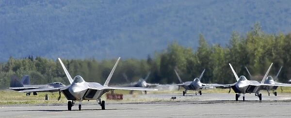 Six F-22 Raptors taxi down the runway