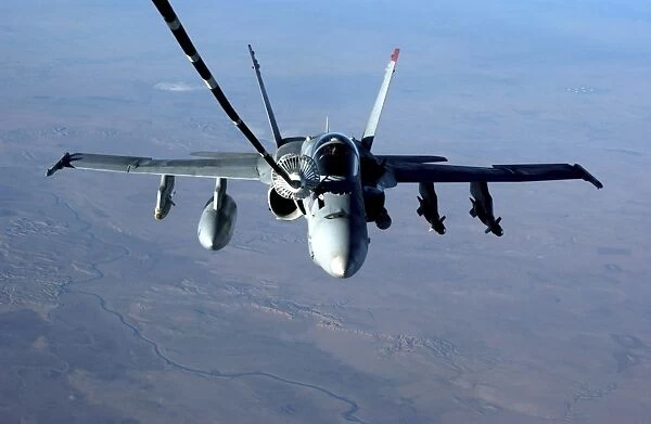 An F  /  A-18C Hornet receives fuel from a U. S. Air Force KC-10 Extender