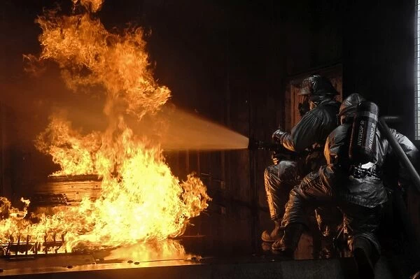 Firefighters extinguish a simulated battery fire
