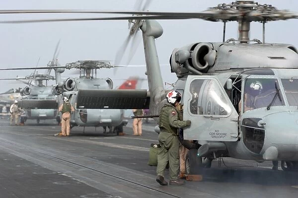 Helicopter crews change out on the flight deck aboard USS Theodore Roosevelt