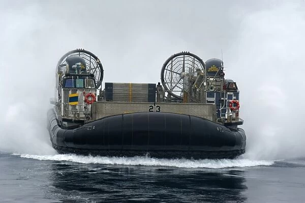 A landing craft air cushion approaches the well deck of USS New Orleans