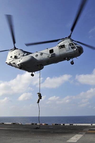 A Marine fast ropes from a CH-46E Sea Knight helicopter