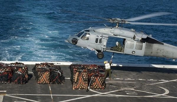 Marines attach cargo to an MH-60S Sea Hawk helicopter