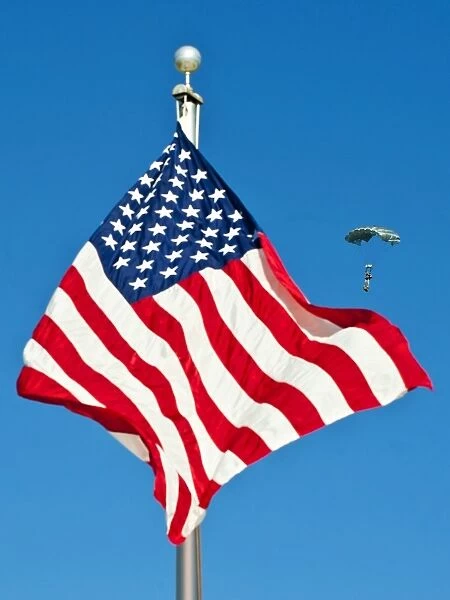 A member of the Armyas Black Daggers parachute team passes by the American flag