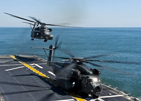 MH-53E Sea Dragon helicopters take off from the flight deck of USS Wasp