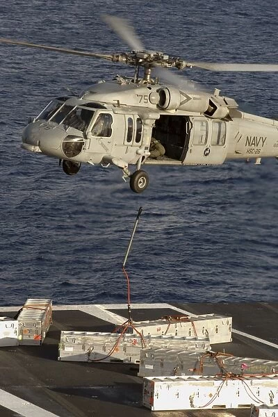 An MH-60S Seahawk delivers ammunition onto the flight deck of USS Theodore Roosevelt