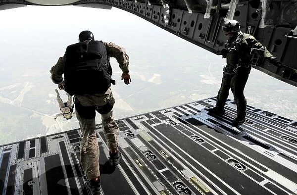Navy SEALs jump from the ramp of a C-17 Globemaster III over Virginia